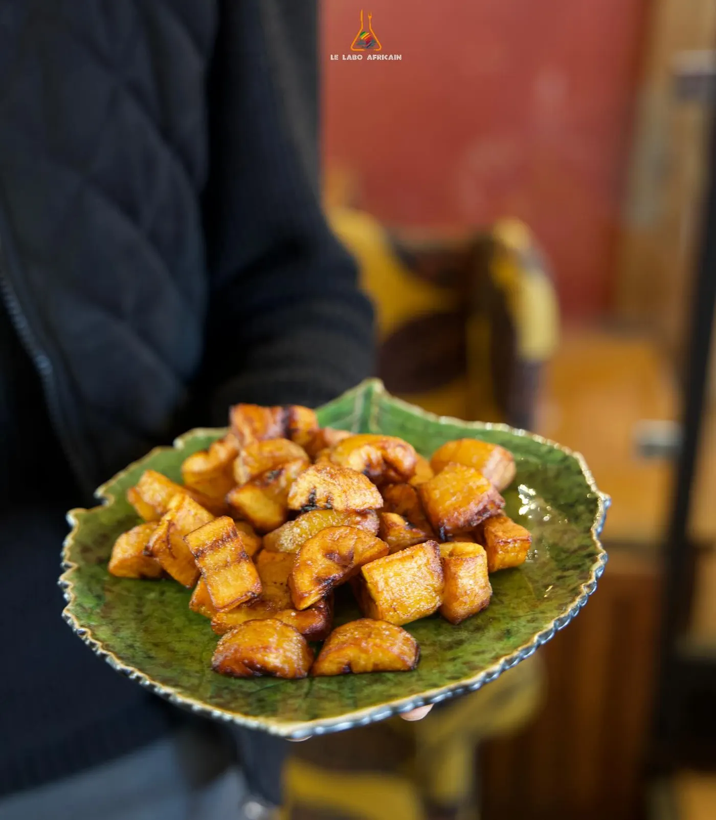 Golden fried alloco plantain on a leaf-print plate