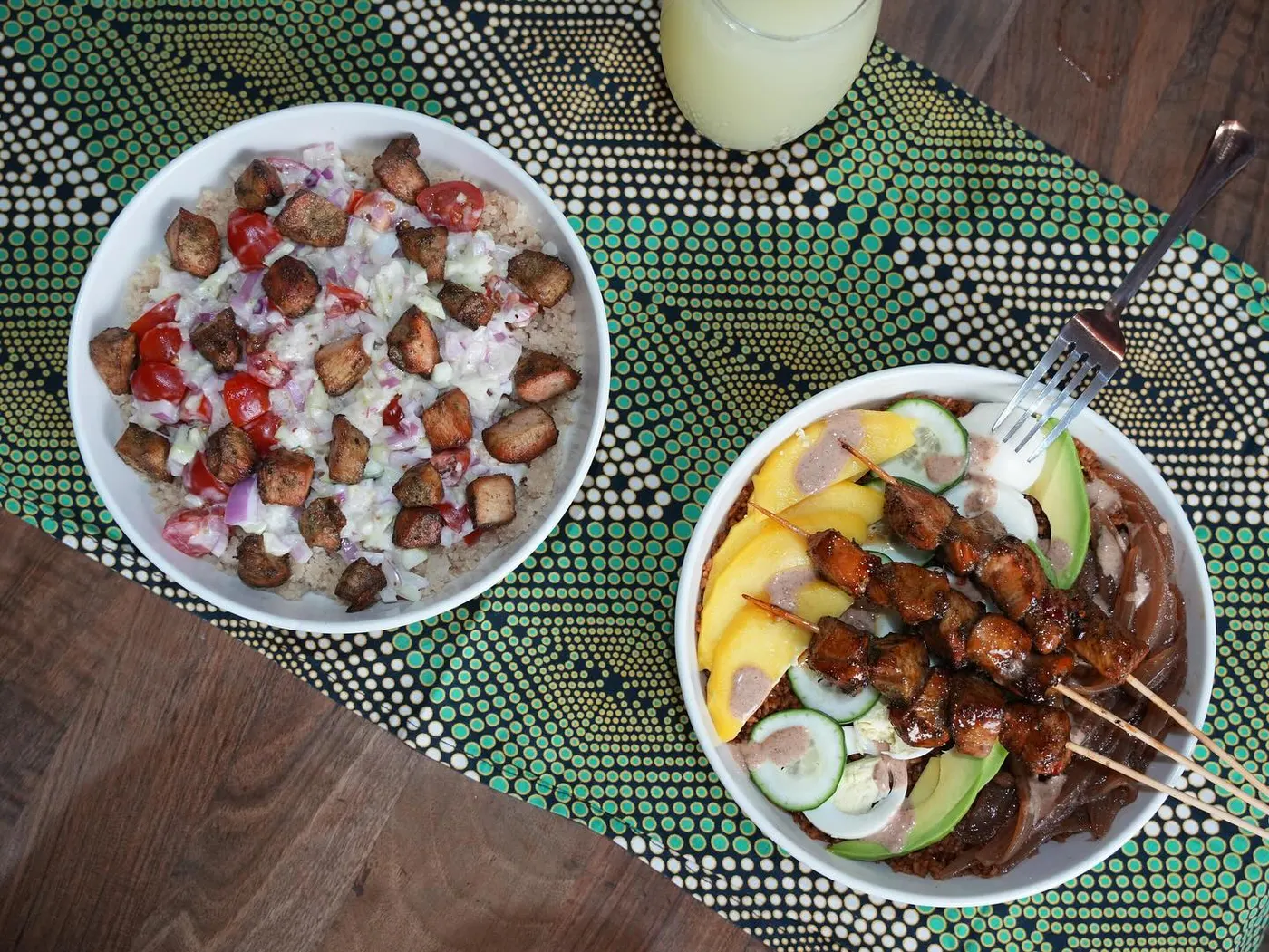 A shared dibi spread of grilled meat and rice on wax print