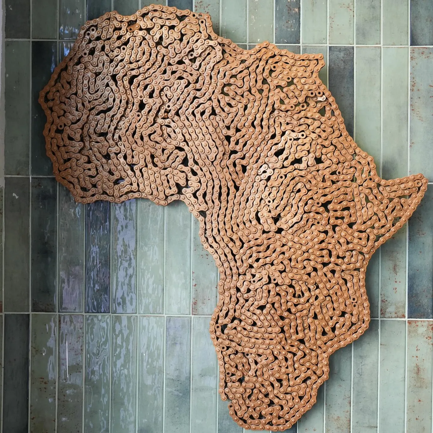 An Africa-shaped lace artwork on the green zellij tile wall